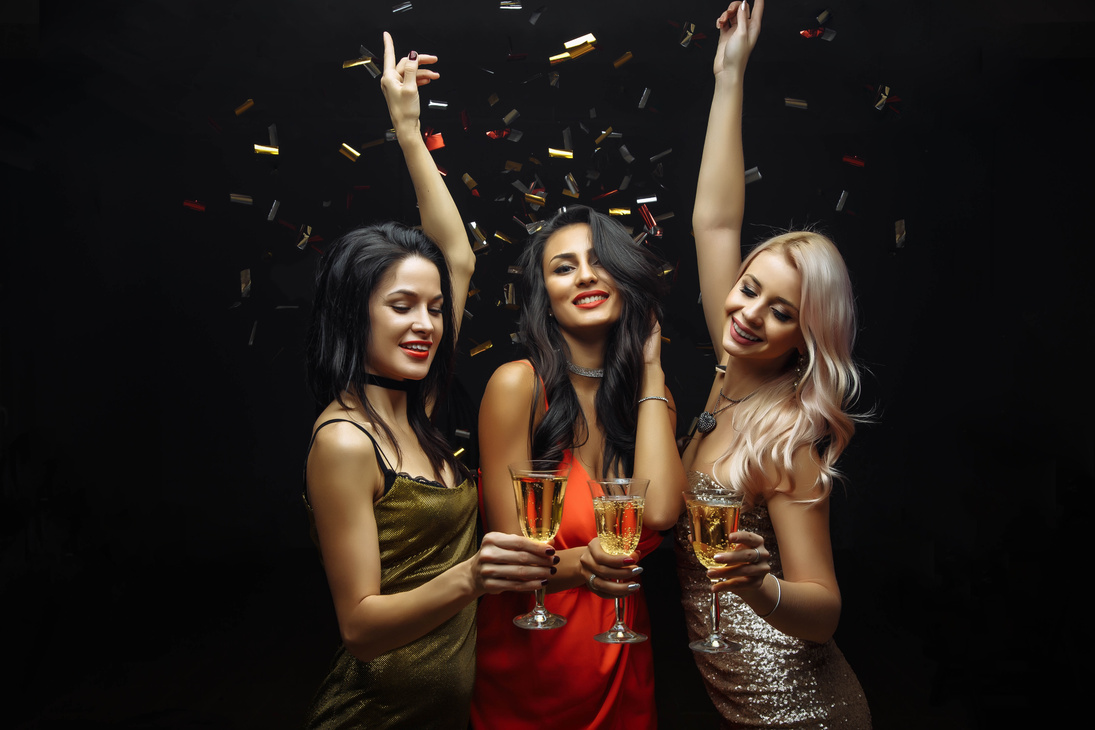 Young attractive women celebrating a party, drinking champagne and dancing.